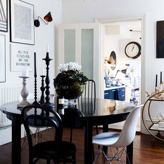 A black and monochrome dining room with a round circular dining table in black