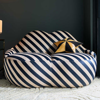 Beautiful blue and white strip lips shape sofa in a living room styled with a gold and black star cushion.