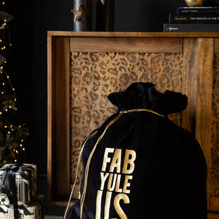 A christmas gift setting with a sack that says "Fab Yule Us" on it