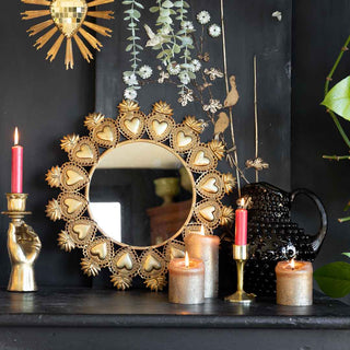 a heart mirror and candles styles on a black shelf