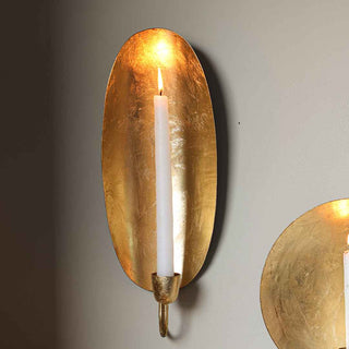 beautiful brass metallic wall sconce with a lit candle.