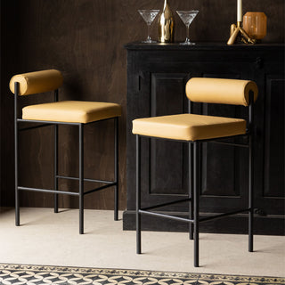 Two Sand Faux Leather Roll Back Bar Stools styled in front of a sideboard styled with barware and home accessories.