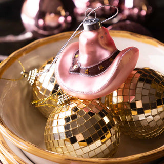 Pink cowboy hat balanced on disco ball decorations.