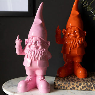 The Fabulous Pink and Orange Naught Gnomes styled on a table with a leopard print book and a plant.