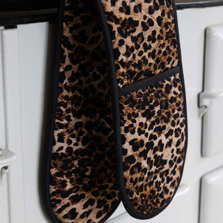 Leopard print oven gloves hanging on an aga handlebar