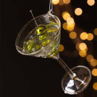 The Martini Glass Christmas Tree Decoration styled hanging in front of a dark background with fairy lights.