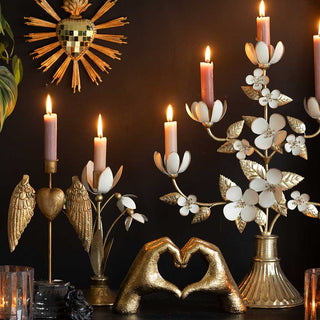 A mantle filled with gold accessories, hearts and candlesticks.