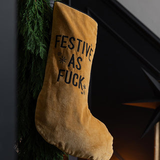 Mustard velvet stocking with the word 'festive as fuck' imprinted on the stocking.