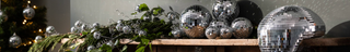 Disco balls on a mantlepiece with a green garland.