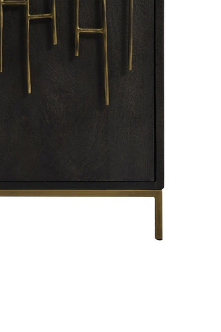 Bottom right corner of black mango wood cabinet, featuring brass stand and antiqued-metal fretwork 