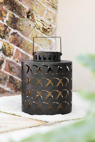 The Beautiful Dancing Birds Outdoor Solar Light on a patio outdoors.