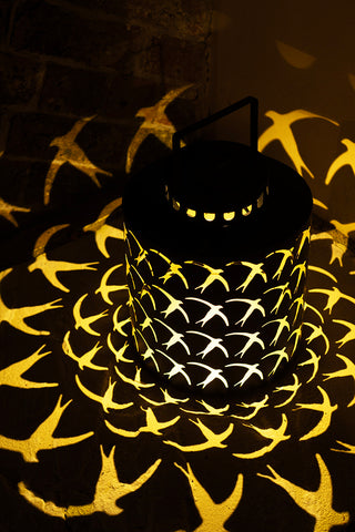 The Beautiful Dancing Birds Outdoor Solar Light switched on in the dark.