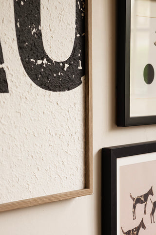 Close-up of the Framed Black & White Ciao Wall Art on the wall with other prints.