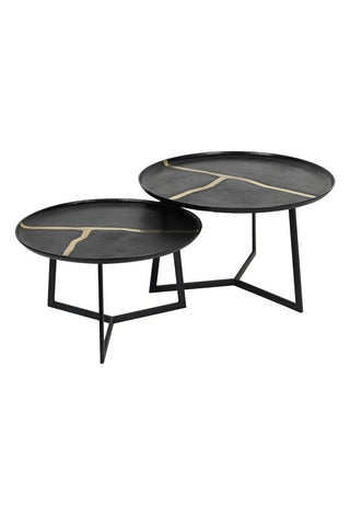 An image of two circular metal tables with gold inlay 