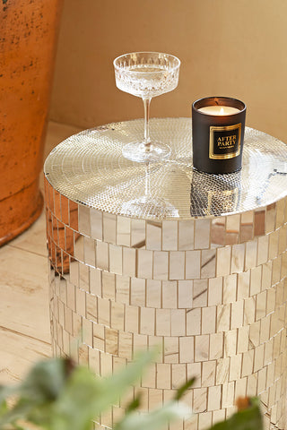 Close-up of the Silver Disco Ball Mirrored Side Table with a glass and candle on.