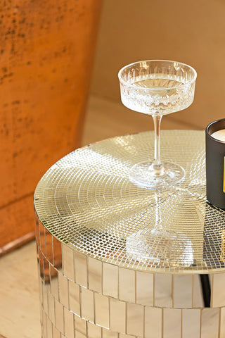 Close-up of the Silver Disco Ball Mirrored Side Table, with a glass on top.