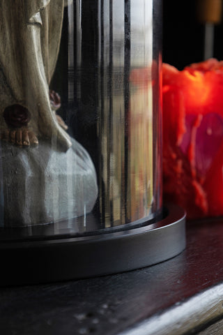 Close-up of the base of the Large Glass Dome Ornament styled with a statue inside.