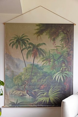 The Large Rainforest Wall Art on a white wall, styled next to a chair and a plant.