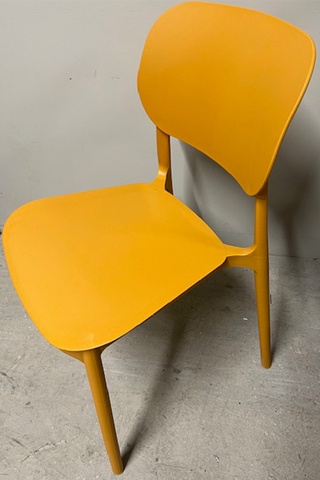 Plastic yellow chair against a grey background