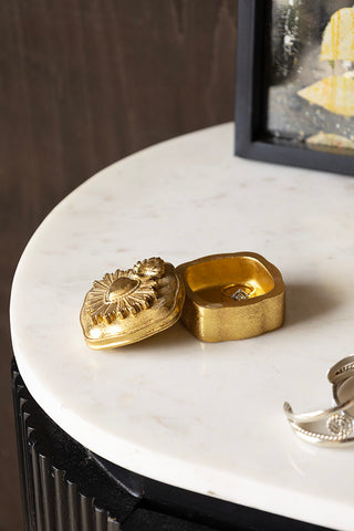 The Ornate Sacred Heart Trinket Box with the lid off, styled on a marble surface with some jewellery and a mirror.