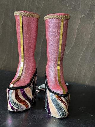 The front of pink platform boots with a mirrored gold line.