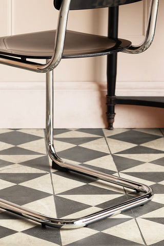 Close-up of the legs of the Retro Inspired Curved Dining Chair in Black, seen from the back.