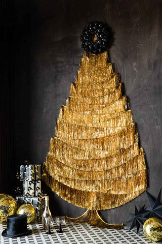 The Gold Tinsel Garland styled as a Christmas Tree on a wood wall