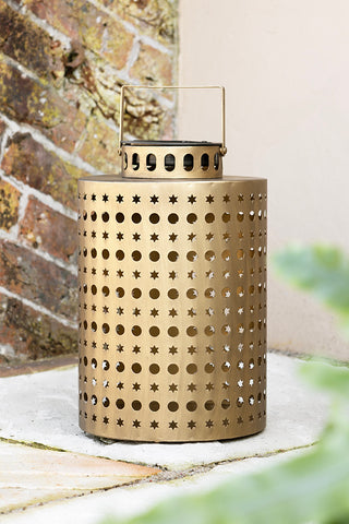 The Pretty Stars Gold Outdoor Solar Light displayed on an outdoor patio.