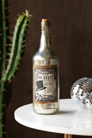 The Vintage-Style Poison Ornamental Glass Bottle styled with some disco balls and a large cactus.