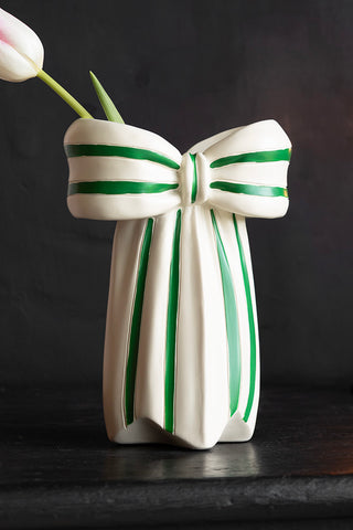 Close-up of the White & Green Beautiful Bow Bud Vase on a dark surface, styled with a tulip inside.