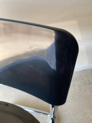 Close up showing a scratch on the backrest of the black retro chair