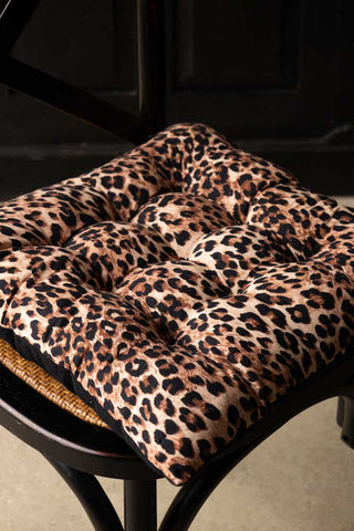 The Leopard Print Seat Cushion styled on a dining chair.