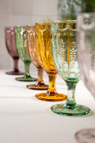 The Set of 6 Colourful Vintage-Style Wine Glasses styled in a line on a kitchen worktop.