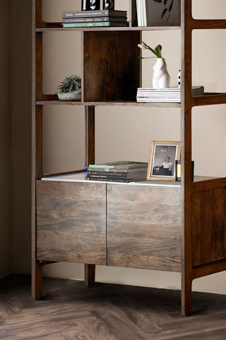 Close-up of the bottom half of the Acacia Wood & Marble Display Cabinet, styled with various home accessories on the shelves.