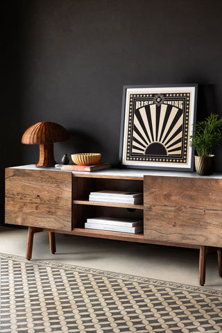 The Acacia Wood & Marble TV Unit styled in front of a black wall with various home accessories on.