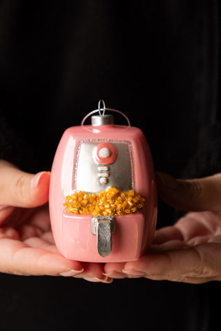 The Air Fryer Christmas Tree Decoration being held in a model's hands.