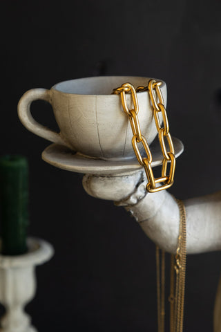 The white teacup on the hand of the quirky balancing rabbit ornament.