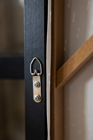 The reverse side of a canvas, showing the hook for hanging.