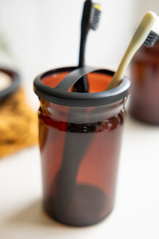 Detail shot of the Apothecary-Style Amber Glass Toothbrush Holder.