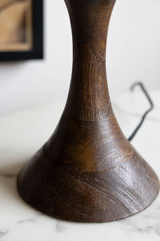 An image of the curved wooden base of a table lamp