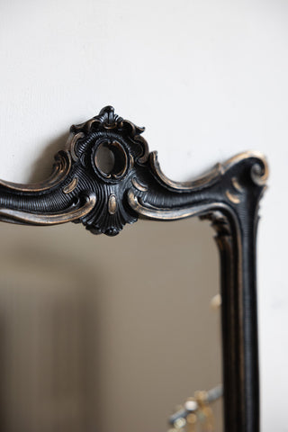 Close-up of the top of the Antique-Inspired Black Framed Mirror.