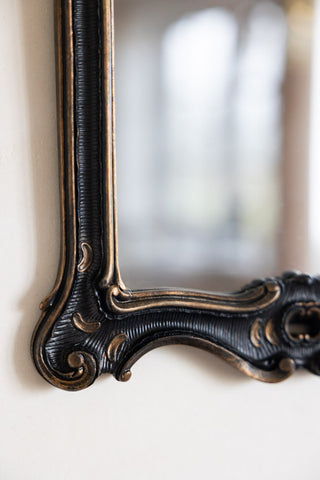 Detail shot of the corner of the Antique-Inspired Black Framed Mirror.