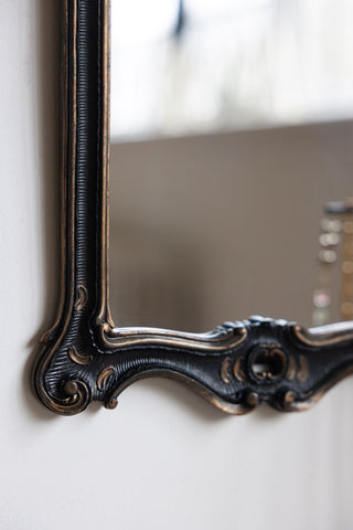 Close-up of the Antique-Inspired Black Framed Mirror on a neutral wall.