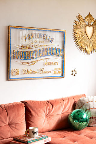 The Antique-Style Gold Framed Portobello Gourmet Wall Art on a white wall with some decorative ornaments, styled above a sofa with various accessories on.