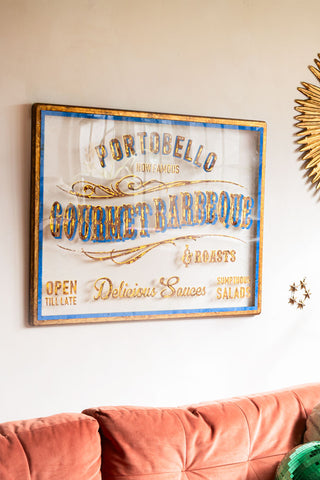 The Antique-Style Gold Framed Portobello Gourmet Wall Art styled on the wall above a sofa.