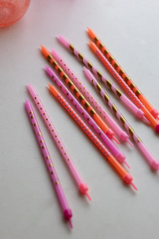 The Assorted Pink Cake Candles - Pack Of 10 displayed laying down on a neutral surface.