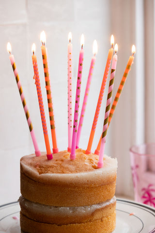 The Assorted Pink Cake Candles - Pack Of 10 lit and displayed in a cake.