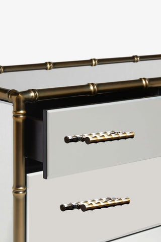 Detail shot of the Mirrored Bamboo Effect Chest Of Drawers with a drawer open, on a white background.