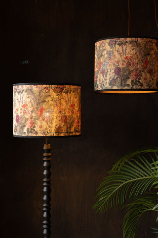 The Bamboo Floral Print Easyfit Lampshade styled on a floor lamp and as a pendant light, in a dark room next to a large plant.