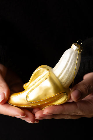 The Banana Christmas Tree Decoration being held in a model's hands.